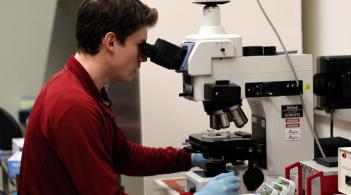 student looking through a microscope