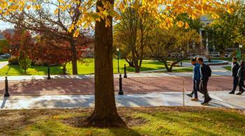 Friends walking together on campus sidewalk