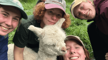 Animal Science Students with a baby Cria Alpaca