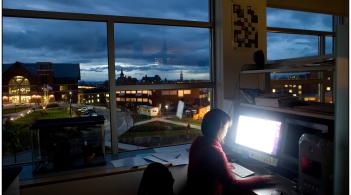 Student on computer at night on campus