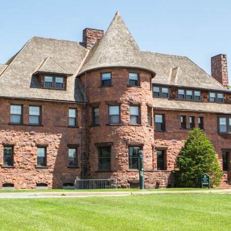 A historic brick building with a round turret. 