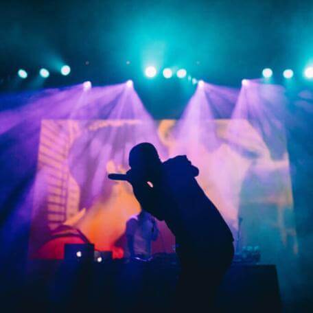 An image of a singer overshrouded by fog and smoke lighting