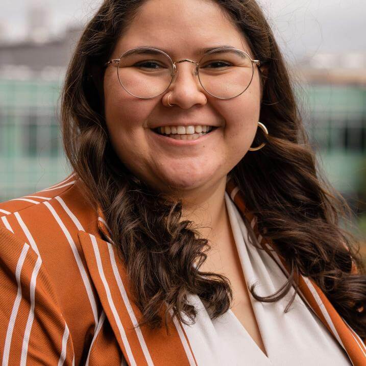 Photo of Jasmine smiling outside of the Davis Center on a cloudy day
