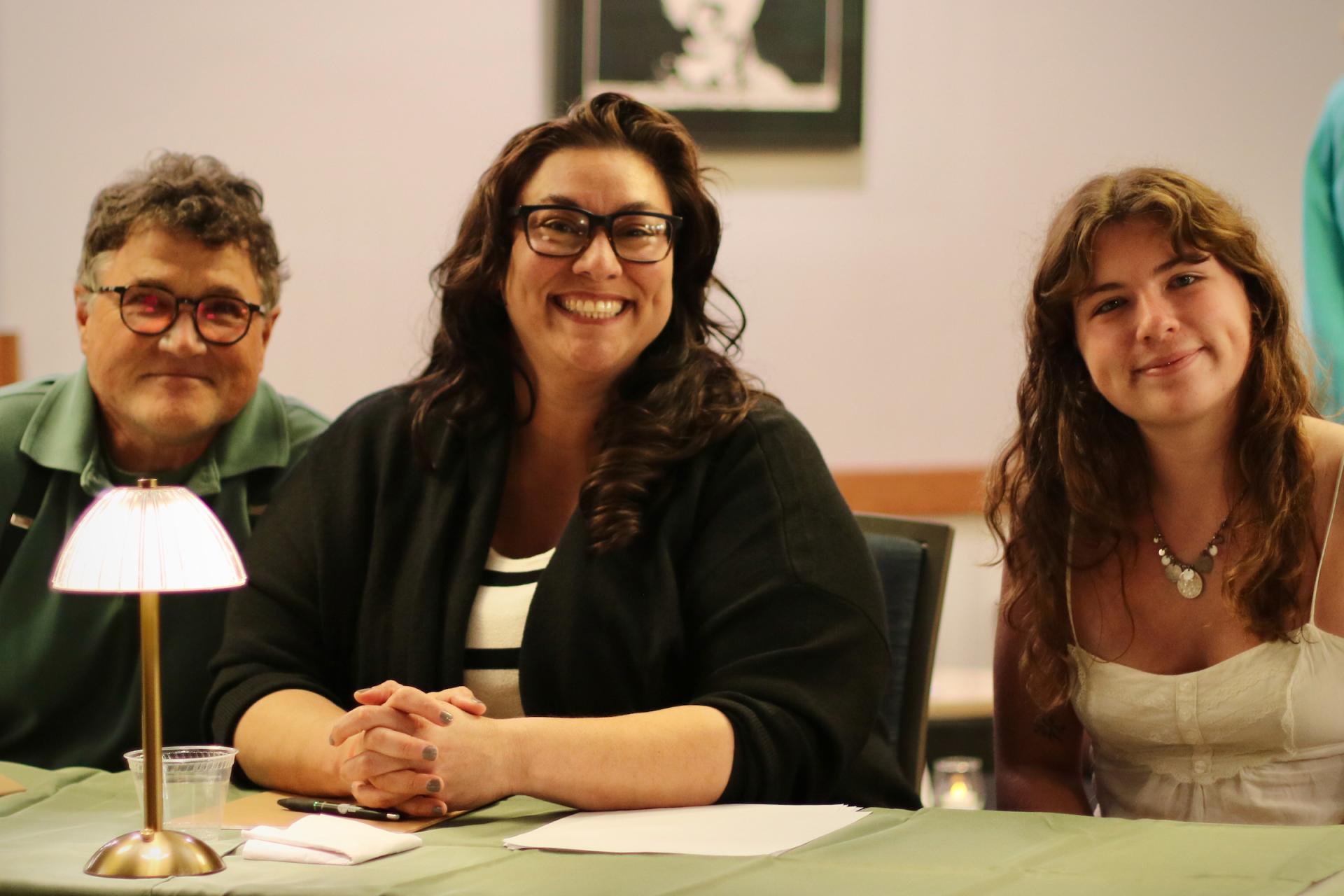 Three people pose and smile for the camera
