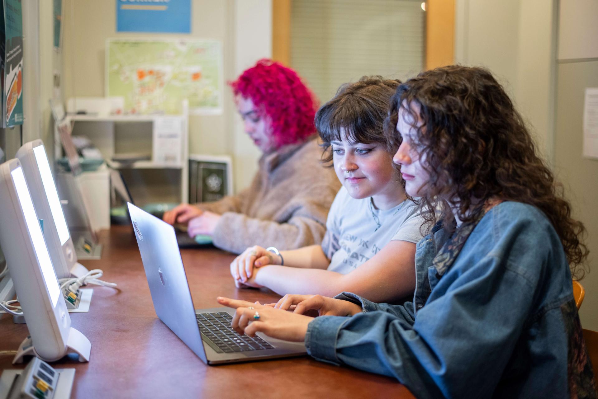 students sit in front of full-spectrum lights on computers at Living Well