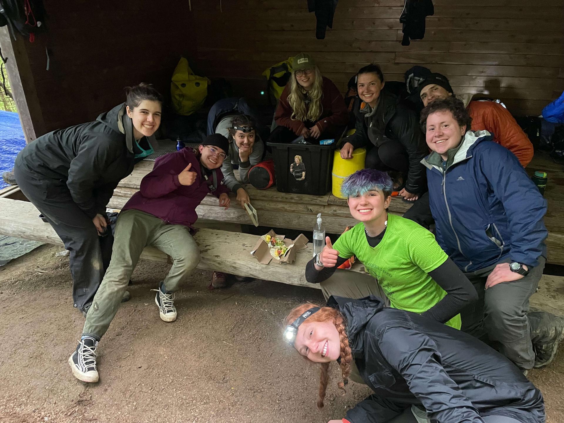 A group of LEAP workers and hiking students posing for a photo around a table