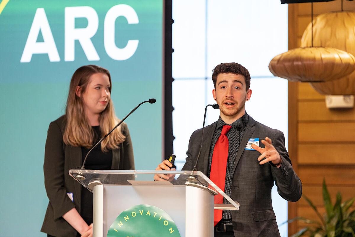 Students give a business presentation at a podium
