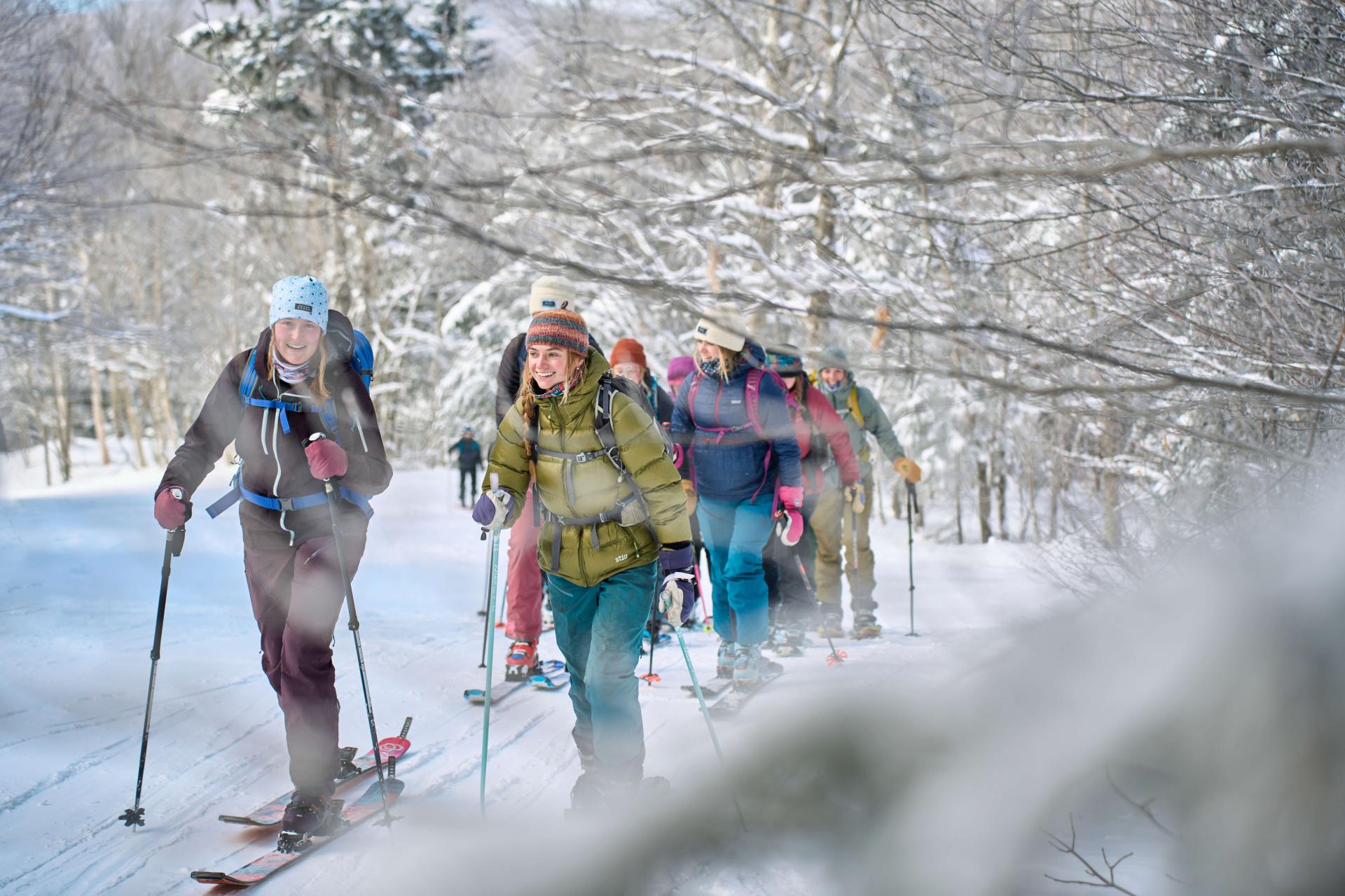 A group of students in Chicks on Sticks skins up Bolton Valley