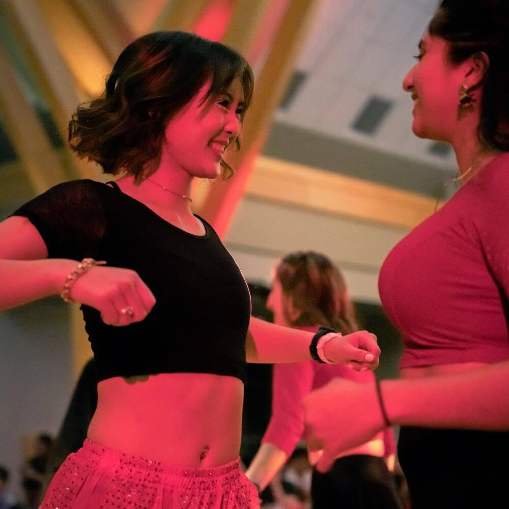 Two students smiling and dancing at Lunar New Year Celebration