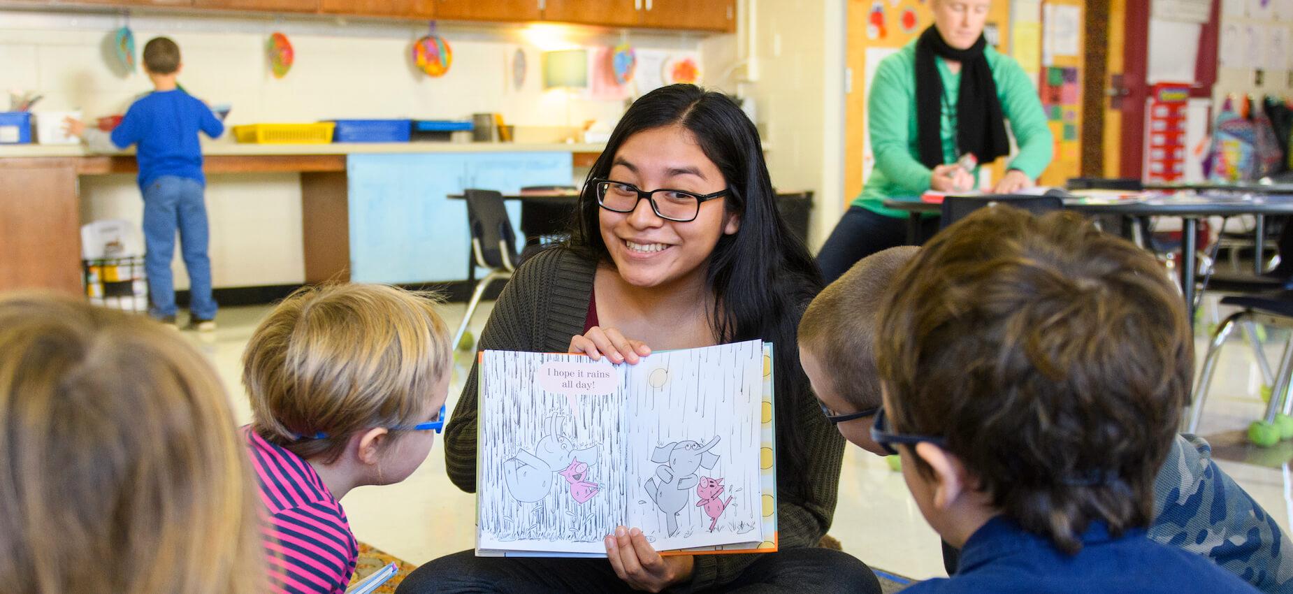 Student teacher reading with children in local school internship.