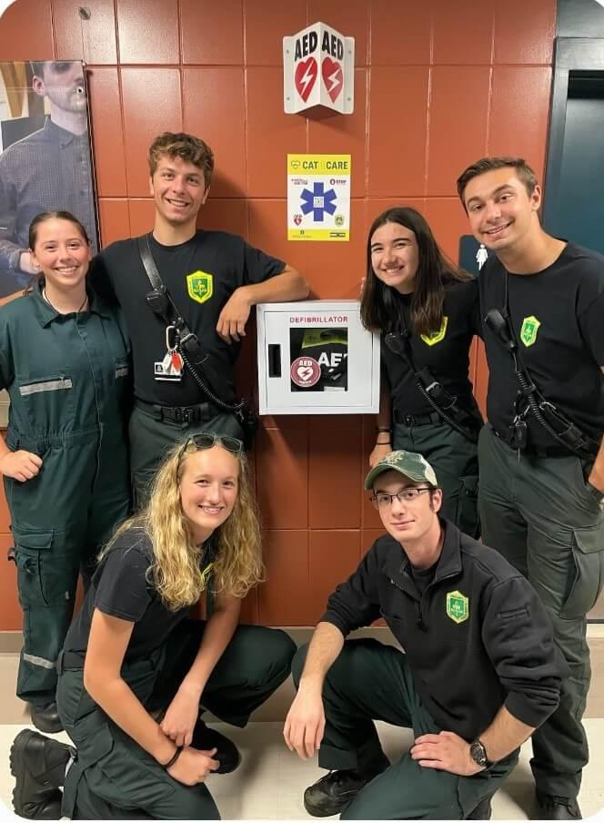 The UVM Rescue Team posing beside a newly installed AED