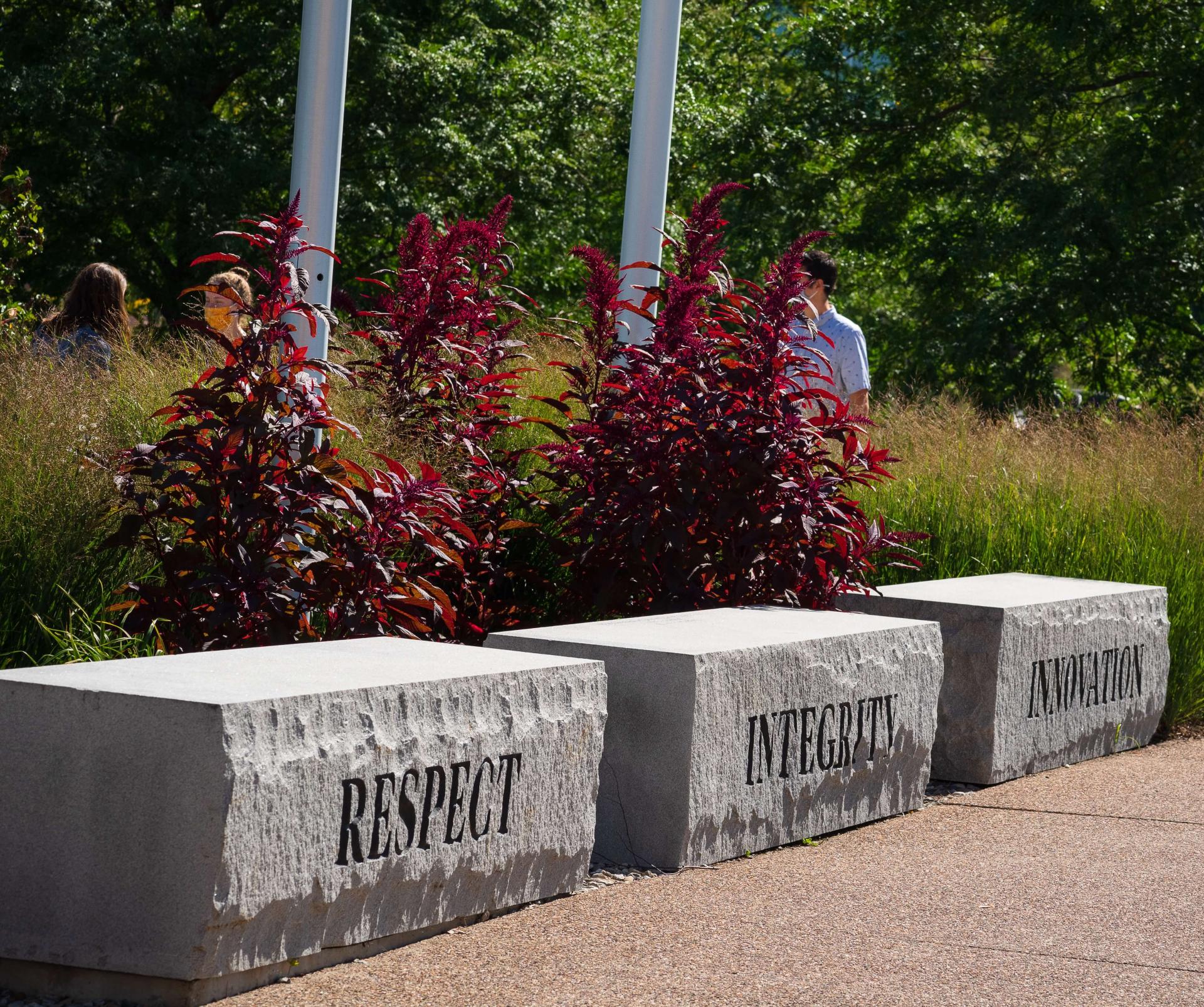 Three stone benches with respect, integrity, and openness carved on them, respectively.