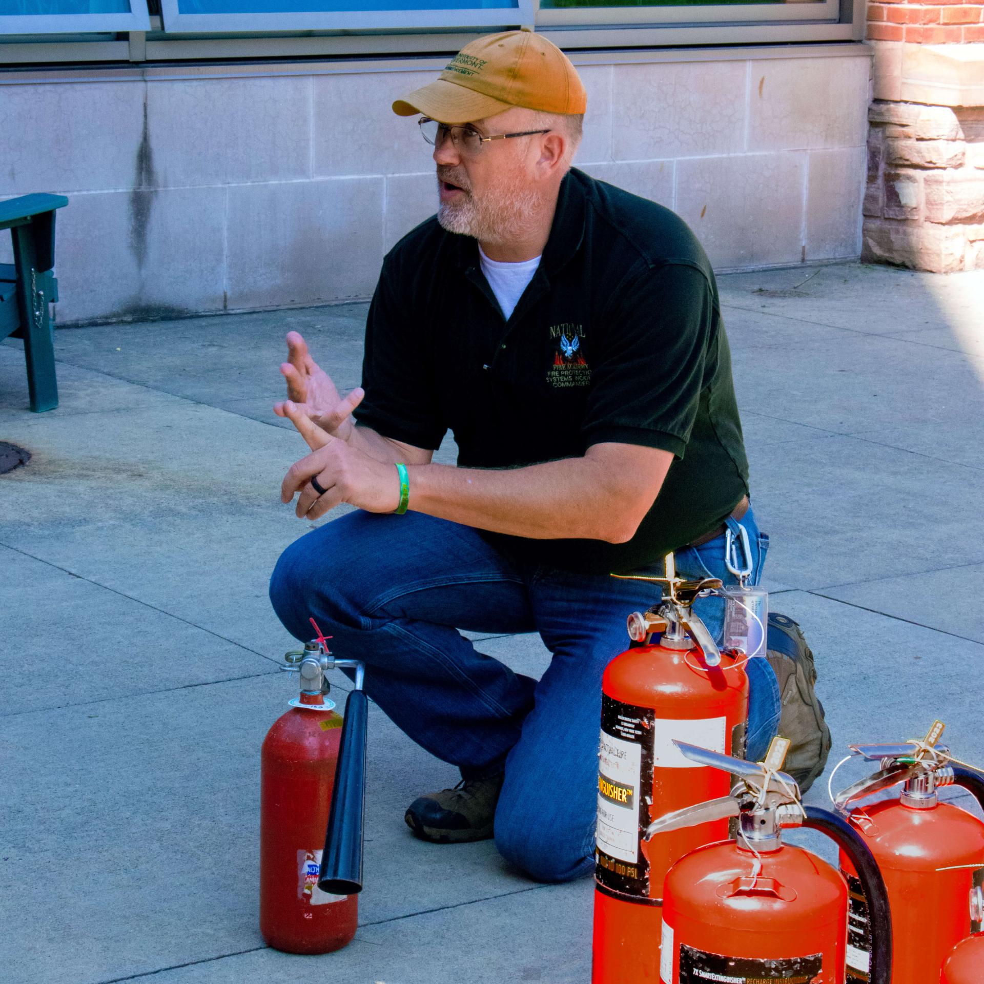 Fire Marshal explains fire safety next to fire extinguishers