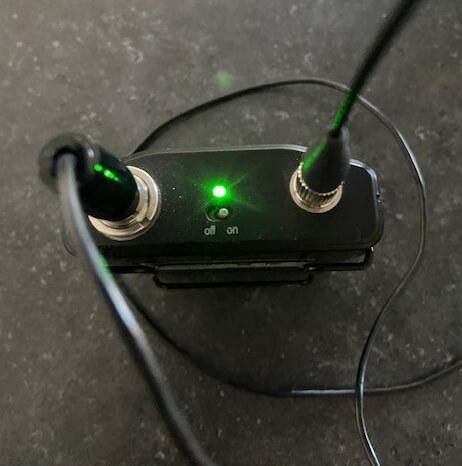 green light on mic pack indicating it's turned on