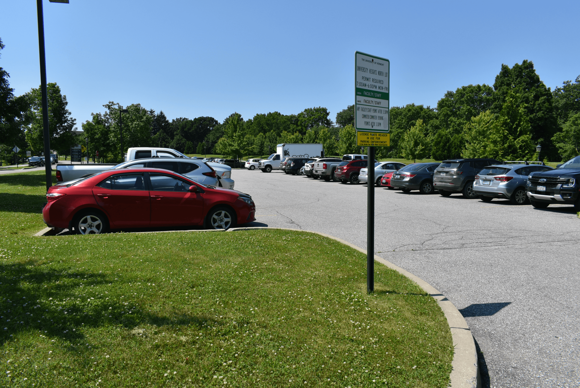 cars parked in a lot with a parking sign on the UVM campus