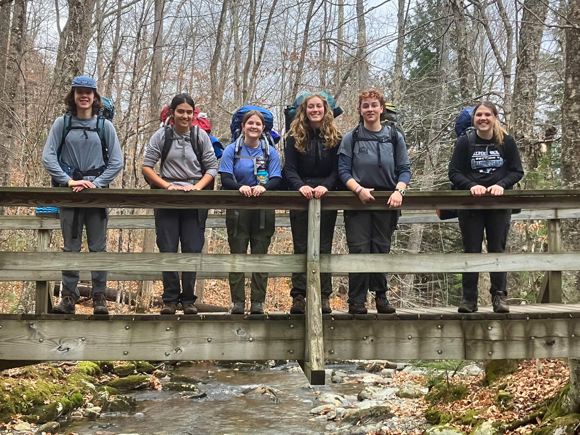 A photo of six UVM students on a bridge during a hike 
