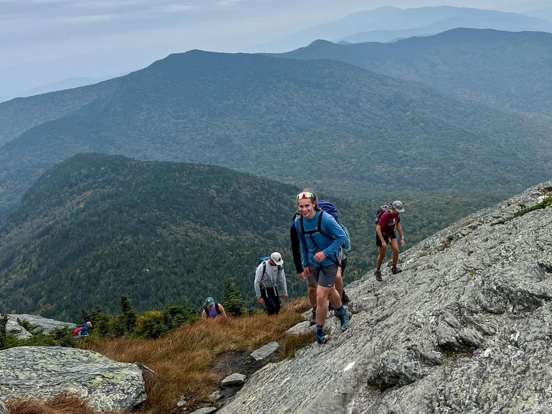A photo of UVM students hiking at the top of a mountain 