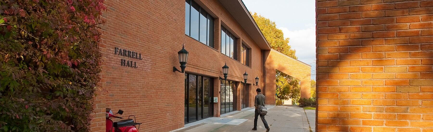 A person walking into Farrell Hall on UVM's Campus