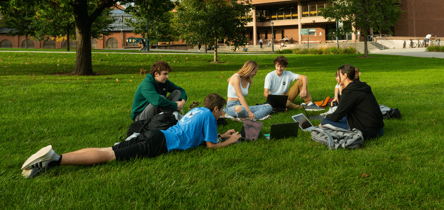 A group of students sitting in the grass in a circle