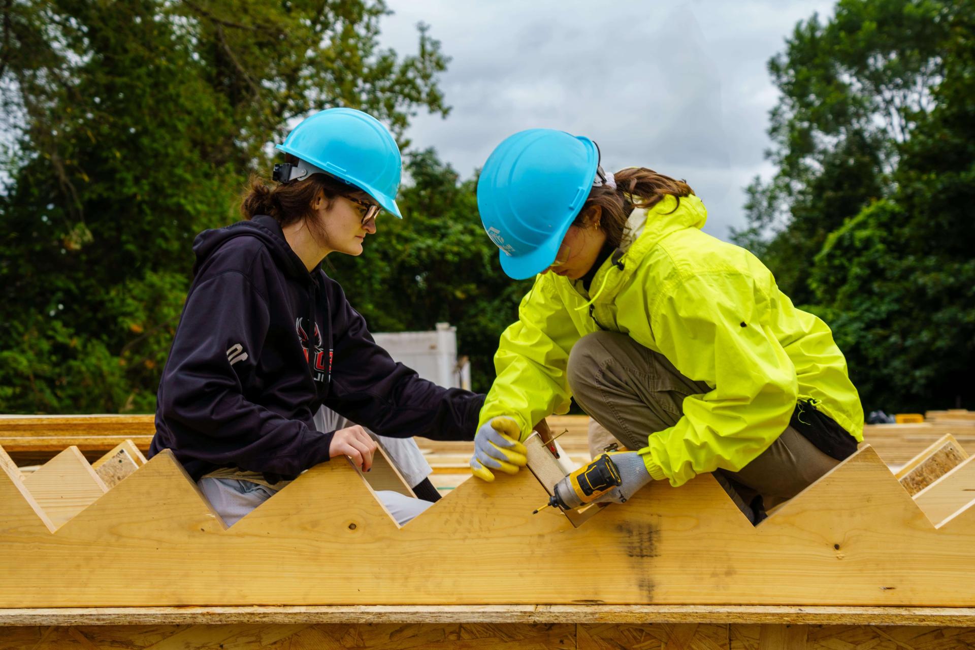 A Trekkie working with wooden planks to build stairs on a service trek trip