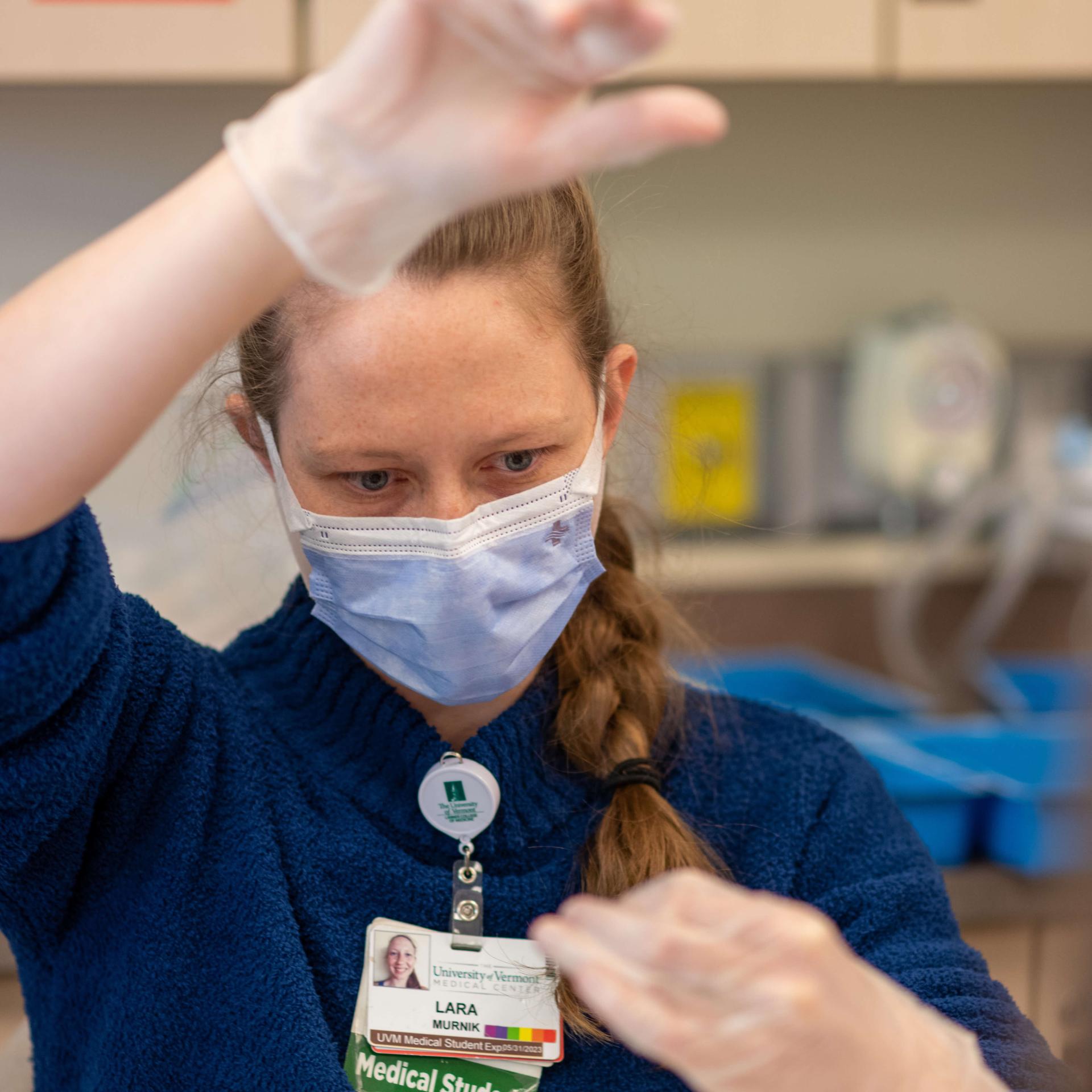 A femme presenting medical student practicing suturing. 