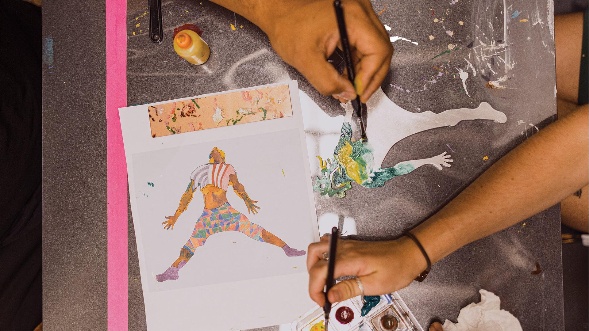 An overhead photo of hands painting 