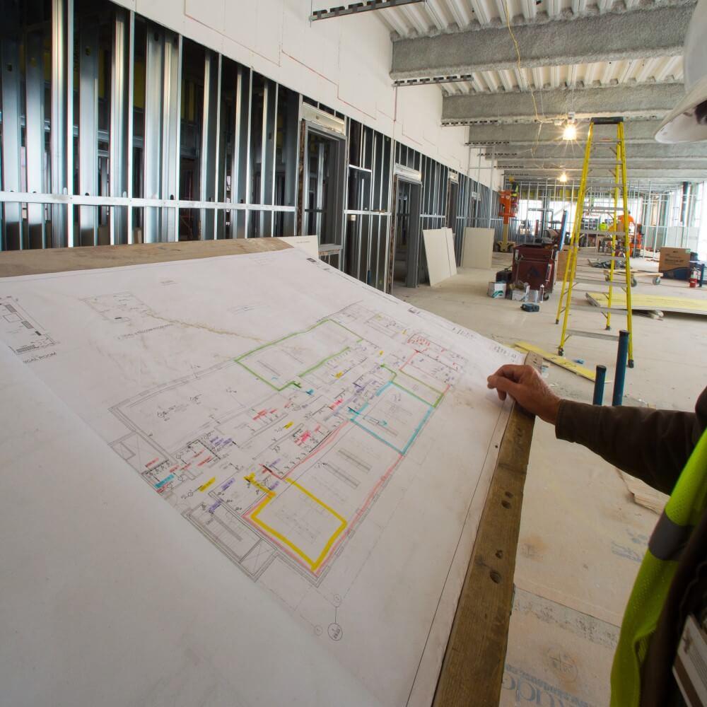 hand of a construction worker pointing to blueprint