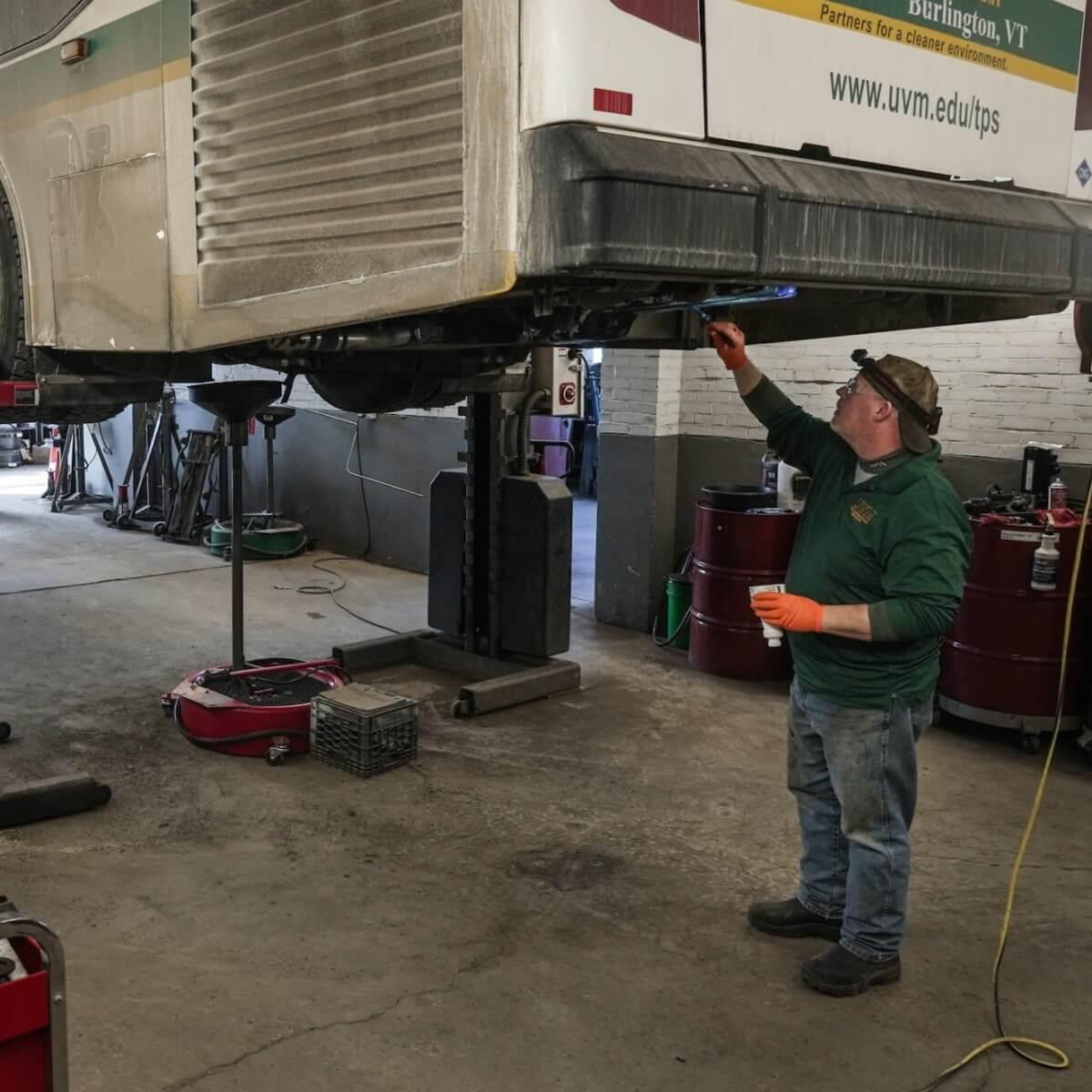 mechanic repairing a large bus engine