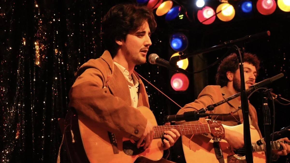 Gus playing the guitar on stage at Radio Bean.