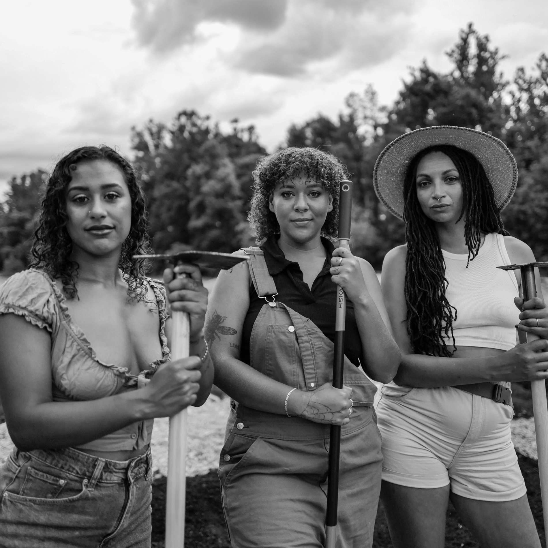 Black and white image of three women farmers, vermont landscape in the background