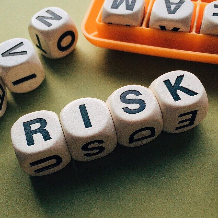 Four dice lined up to spell out the word "risk".