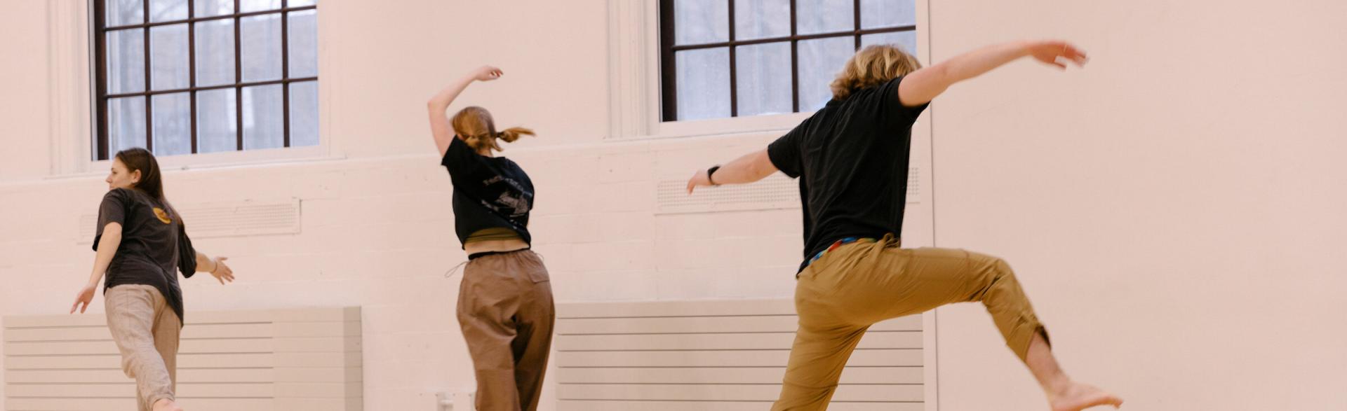 Three people practicing dancing  