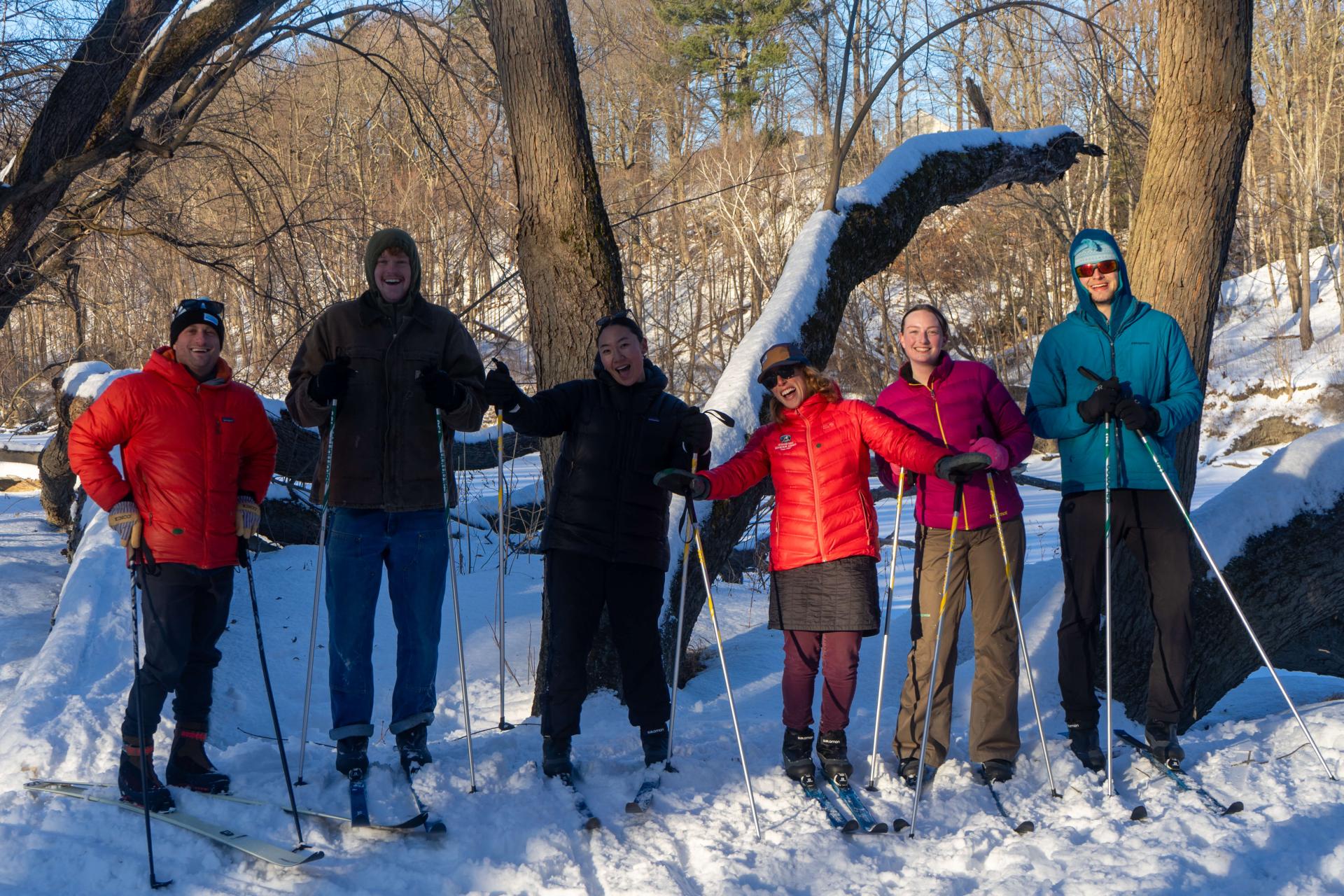 A group of Outdoor Programs staff smile while cross country skiing near campus