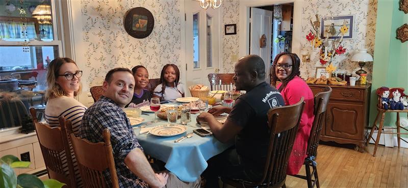 Students enjoying Thanksgiving meal with hosts