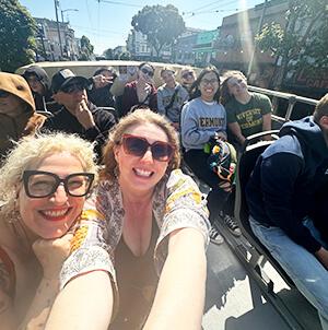 group of smiling students on an open bus in San Francisco