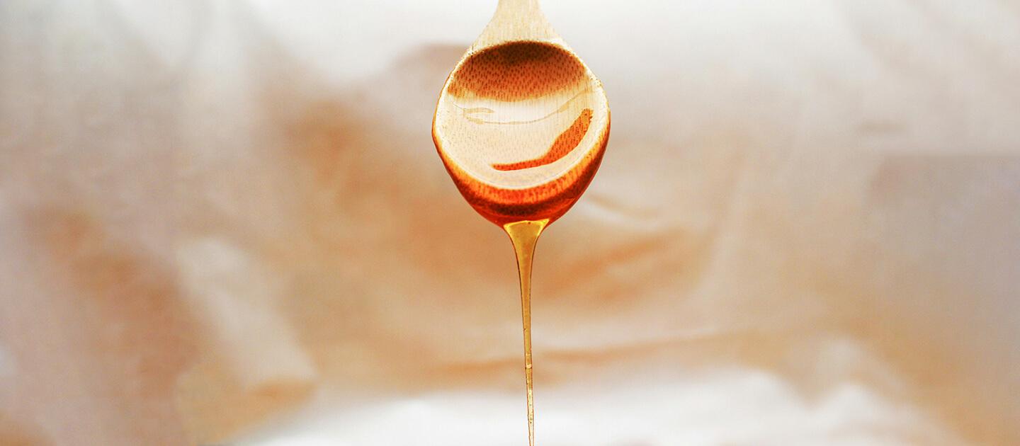 syrup dripping off of a wooden spoon