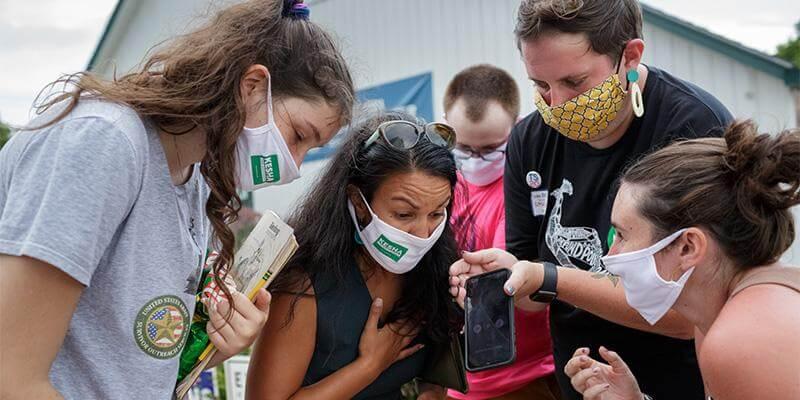 Group of campaigners clustered around cell phone