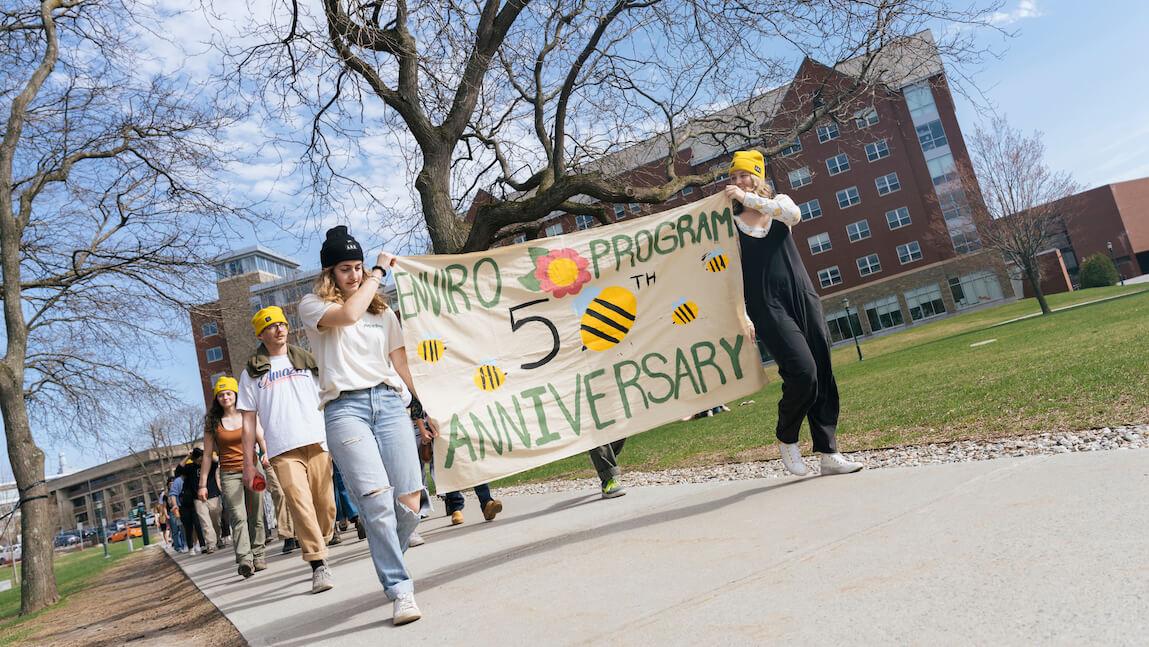 Students walking with 50th Anniversary banner